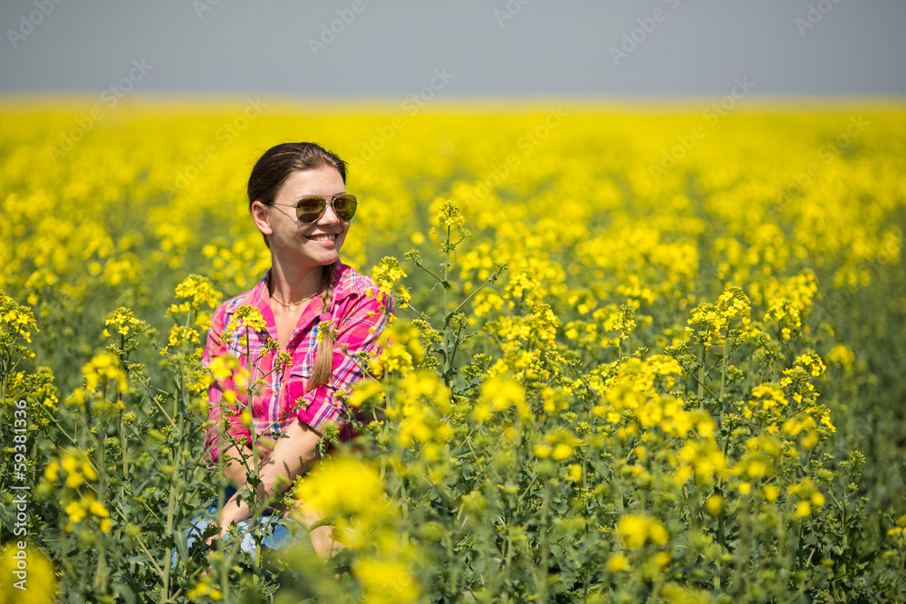 Young beautiful woman in flowering field in summer. Outdoors Young beautiful woman in flowering field in summer. Outdoors