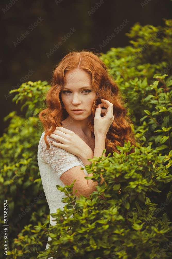 Portrait of young beautiful redhair woman standing in green park Portrait of young beautiful redhair woman standing in green park