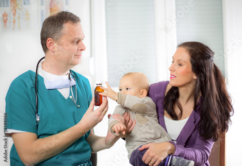 pediatric doctor giving pills bottle to mother with baby