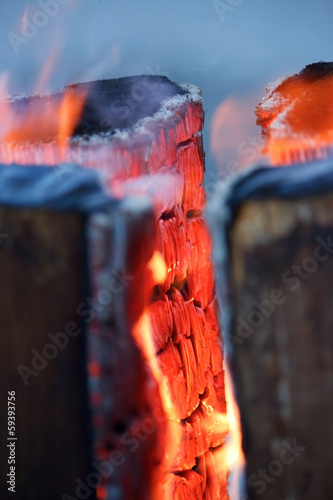 Logs in fire with burning red wood , vertical photo