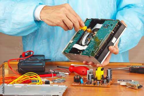 Master parses electronic device for repair in service workshop