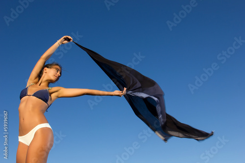 young dancer with scarf at the beach