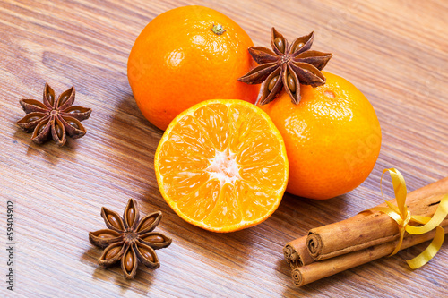 Orange fruit, cinnamon sticks and anise stars on wooden table