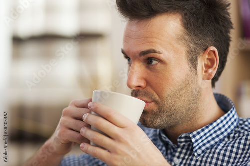 Close up man drinking coffee in home