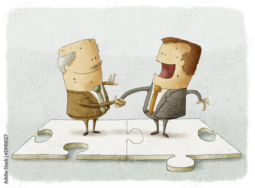 two business people on a puzzle make a handshake