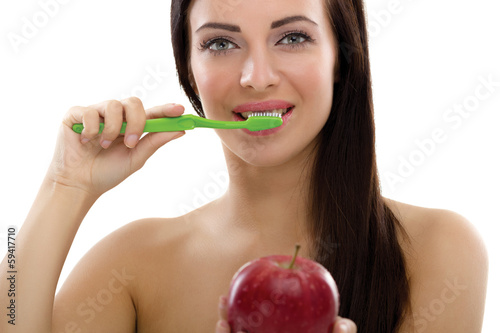 beautiful young healthy woman holding a toothbrush and a red app