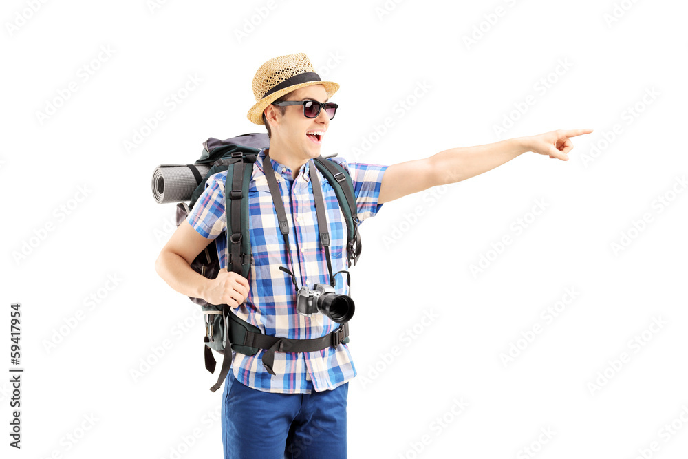 Smiling male tourist with backpack pointing with his finger Smiling male tourist with backpack pointing with his finger