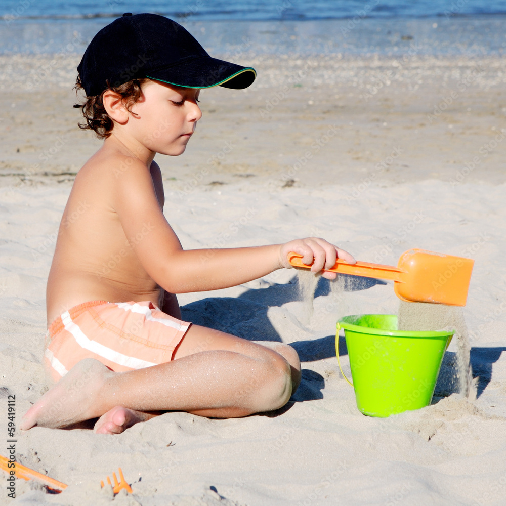 Little boy with hat playing on beach Little boy with hat playing on beach