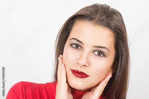 Pretty young woman with red sequins on her lips
