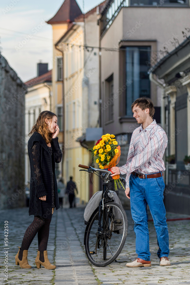 young woman surprised by her date who brings flowers