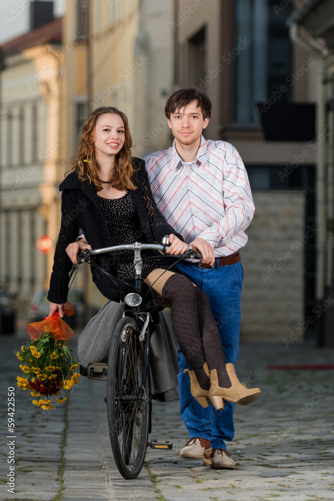 young man pushing his girlfriend on the bicycle