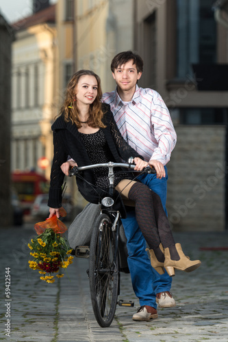 young man pushing his girlfriend on the bicycle