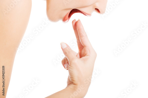 Canvas Print Young woman provoking to vomit.