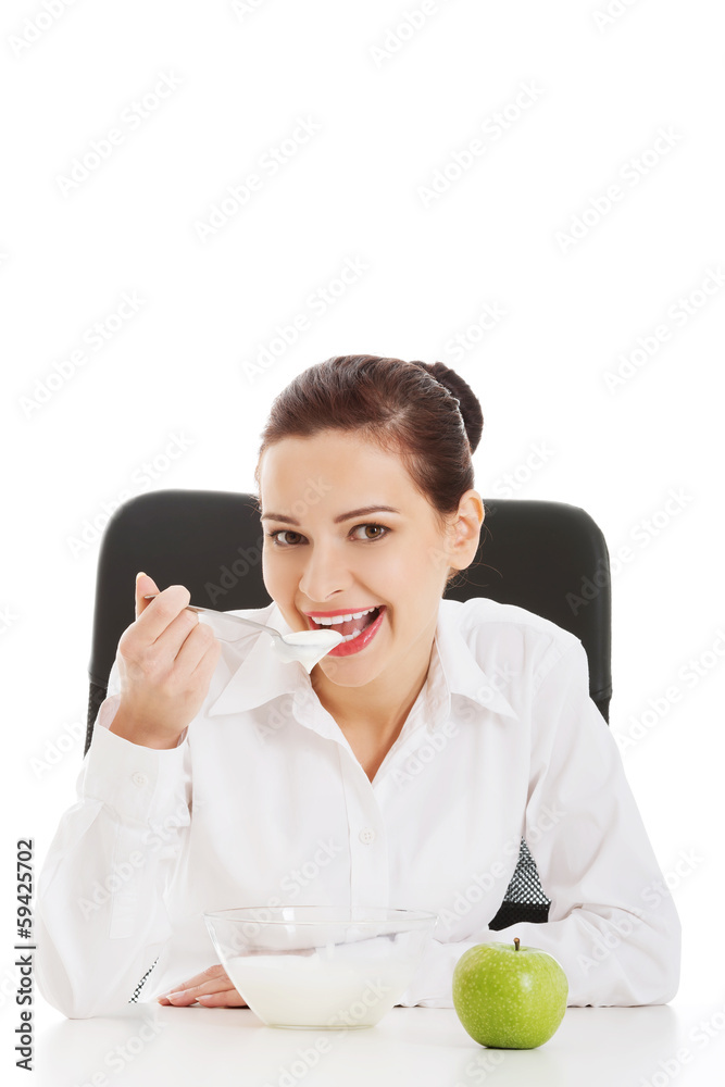 Beautiful young business woman sitting and eating apple and yogh Beautiful young business woman sitting and eating apple and yogh
