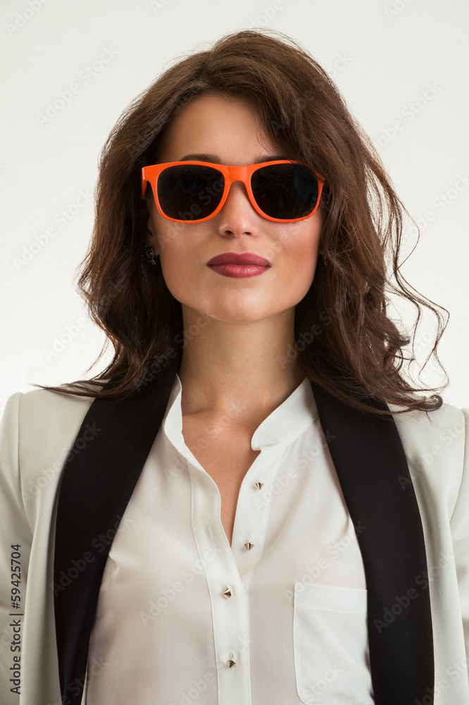 Beautiful business woman wearing sunglasses over a white backgro Beautiful business woman wearing sunglasses over a white backgro