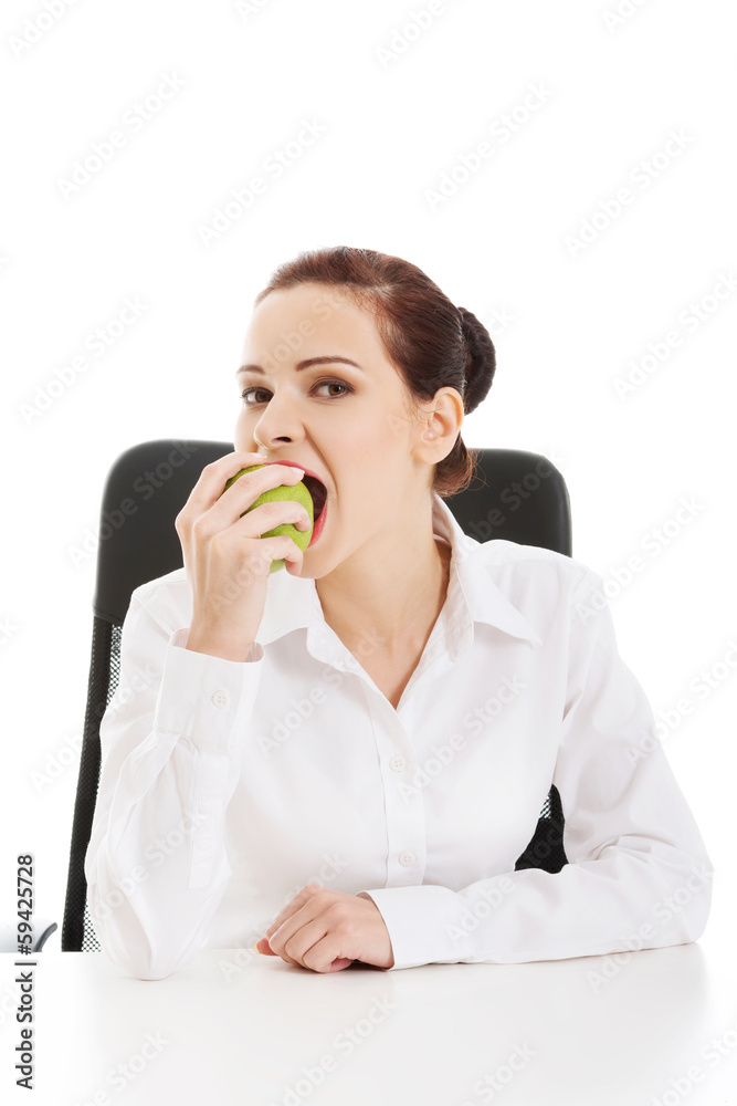 Beautiful young business woman eating an apple. Beautiful young business woman eating an apple.