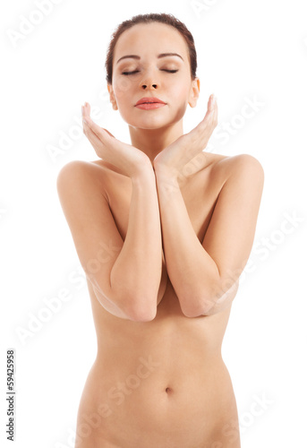 Beautiful naked woman with her hands near face.