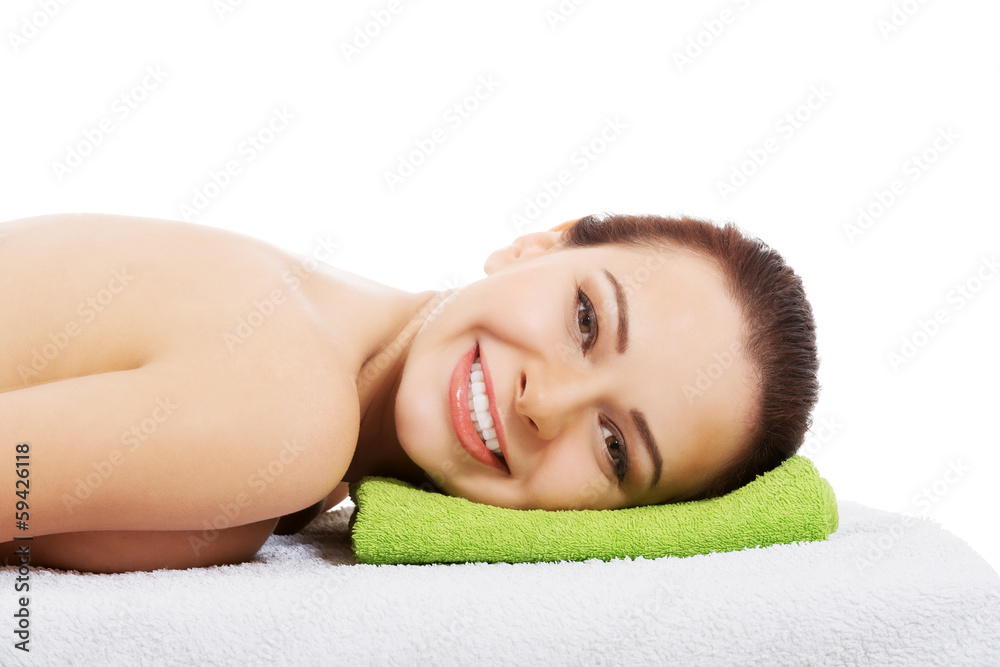 Beautiful woman lying at spa salon.