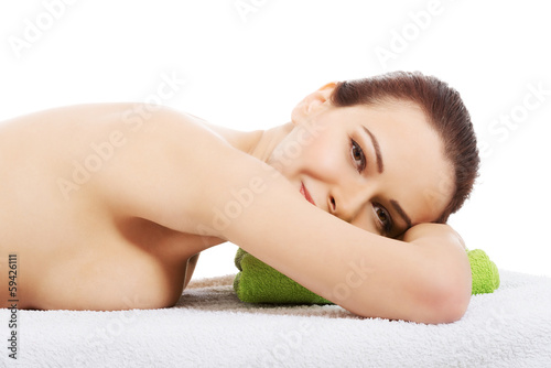 Beautiful woman lying at spa salon.