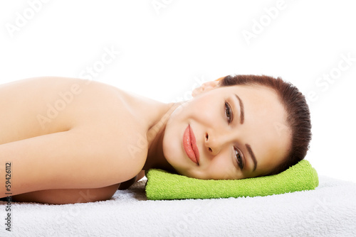 Beautiful woman lying at spa salon.
