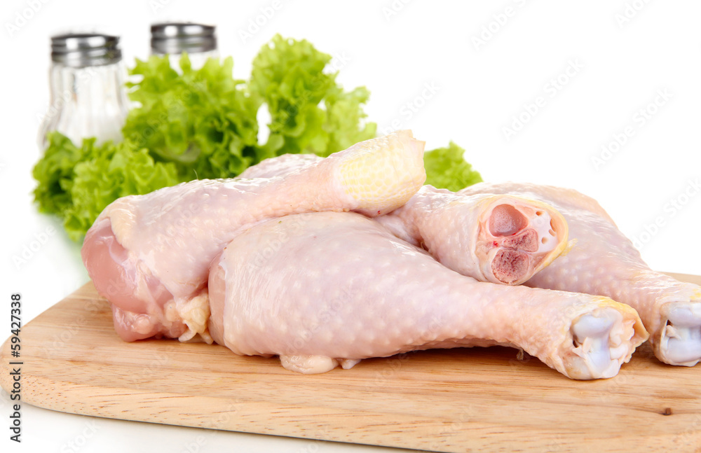 Raw chicken legs on wooden board close up