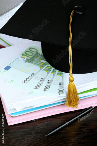 Money for graduation or training on wooden table close-up