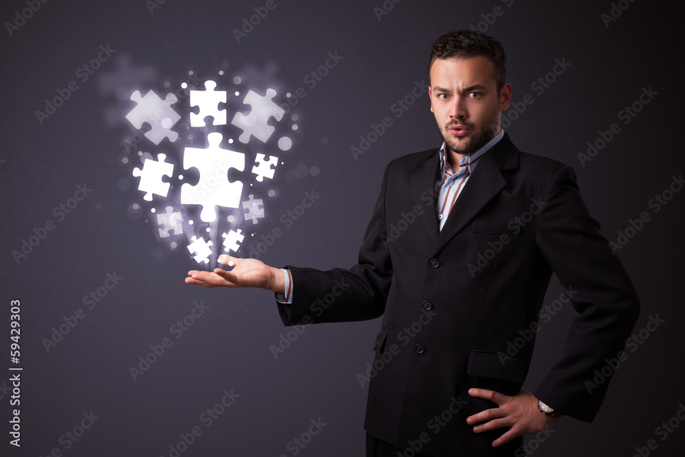 Puzzle pieces in the hand of a businessman Puzzle pieces in the hand of a businessman