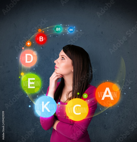 Young woman thinking with vitamins circulation around her head photo