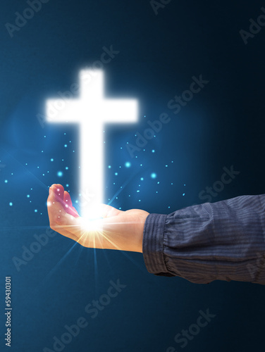 Glowing cross in the hand of a woman