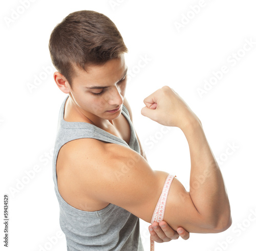 Fit man measuring his muscle biceps