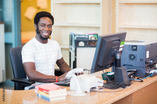 Male Librarian Working At Desk