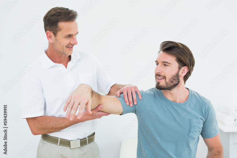 Obraz premium Male physiotherapist massaging a man's arm