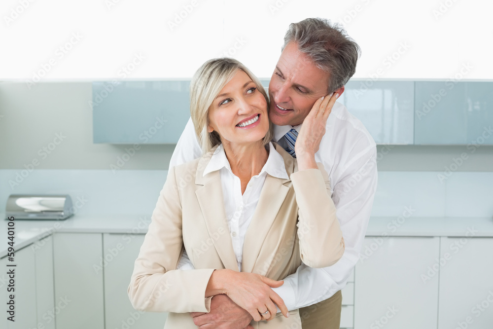 Man embracing happy woman from behind in kitchen Man embracing happy woman from behind in kitchen