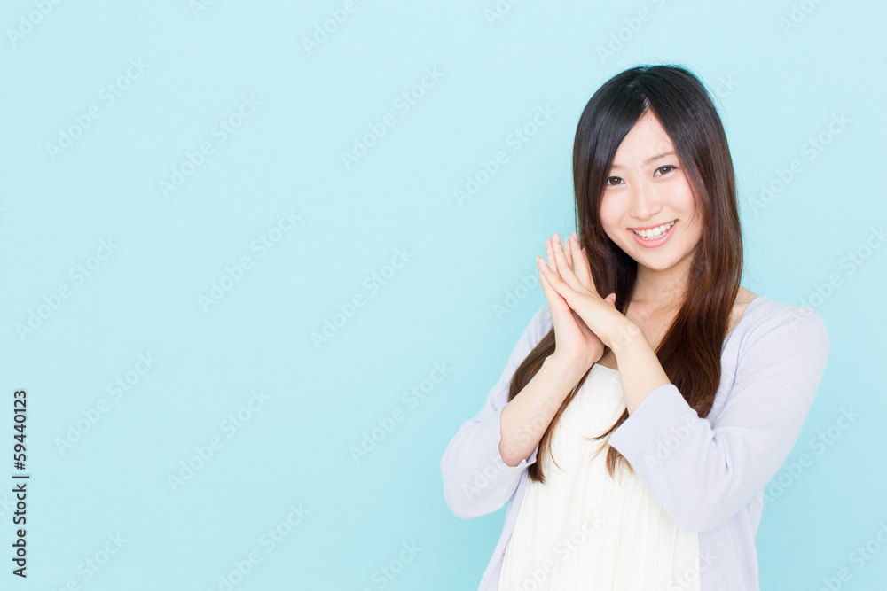 young asian woman cheering on blue background young asian woman cheering on blue background