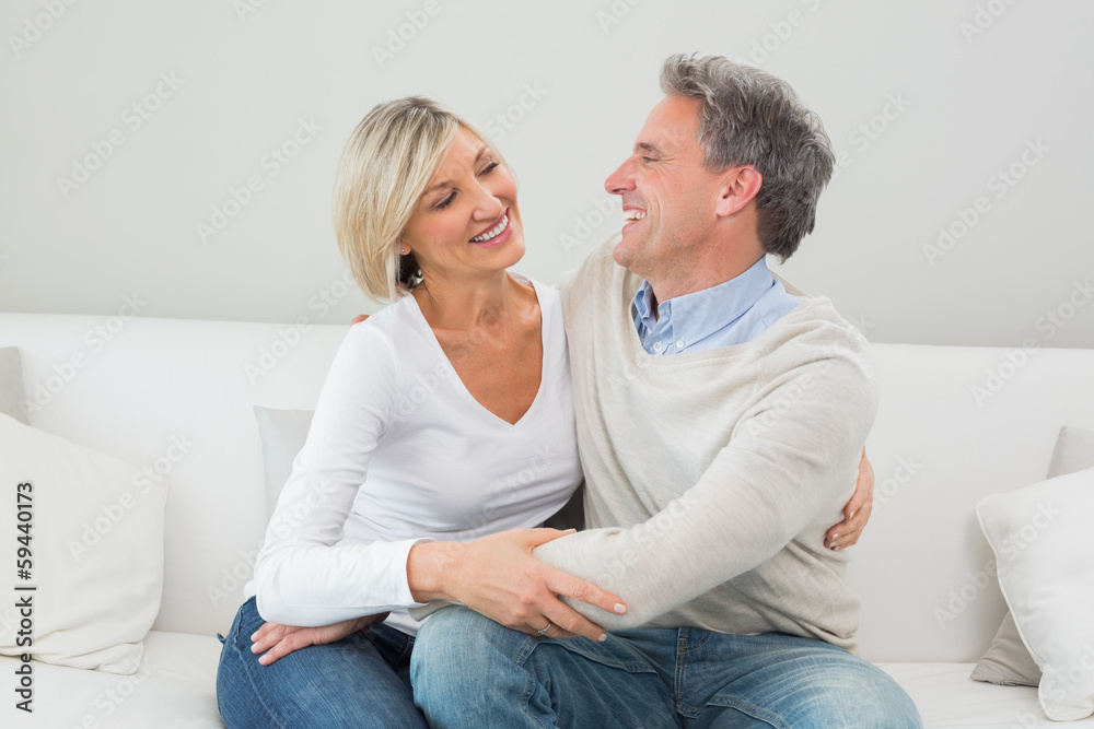 Happy couple embracing in the living room