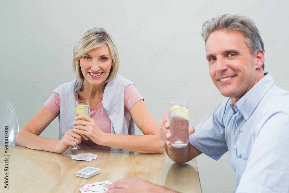Couple with lime juices while playing cards at home Couple with lime juices while playing cards at home