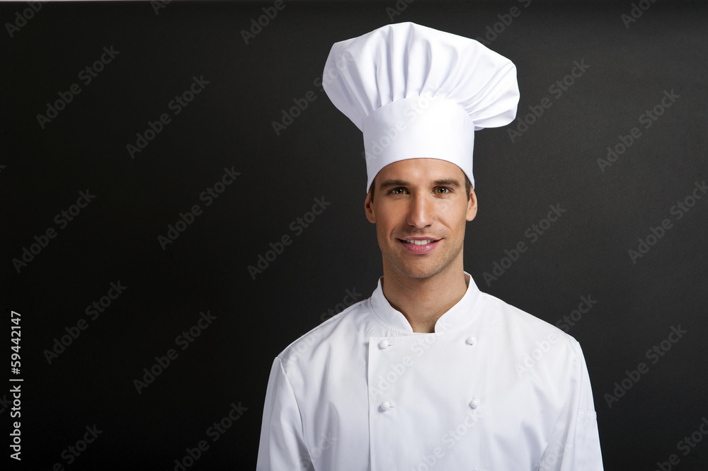 Chef cook against dark background smiling with hat Chef cook against dark background smiling with hat