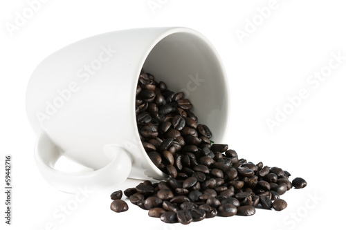 Spilled coffee beans on white ceramic cup