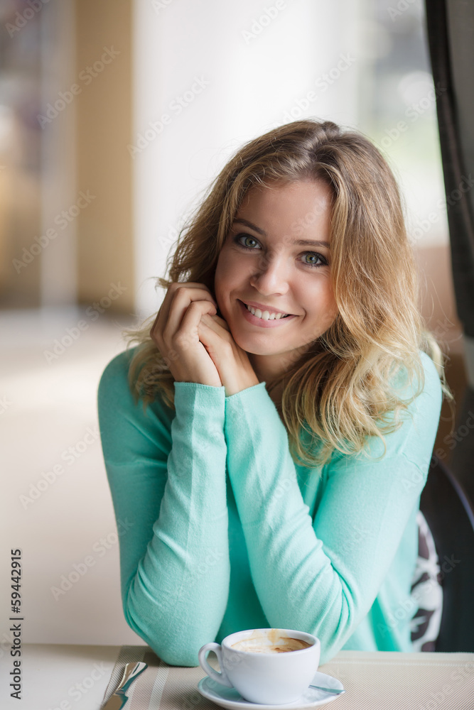 Portrait of a cute blond smiling woman sitting in a cafe Portrait of a cute blond smiling woman sitting in a cafe