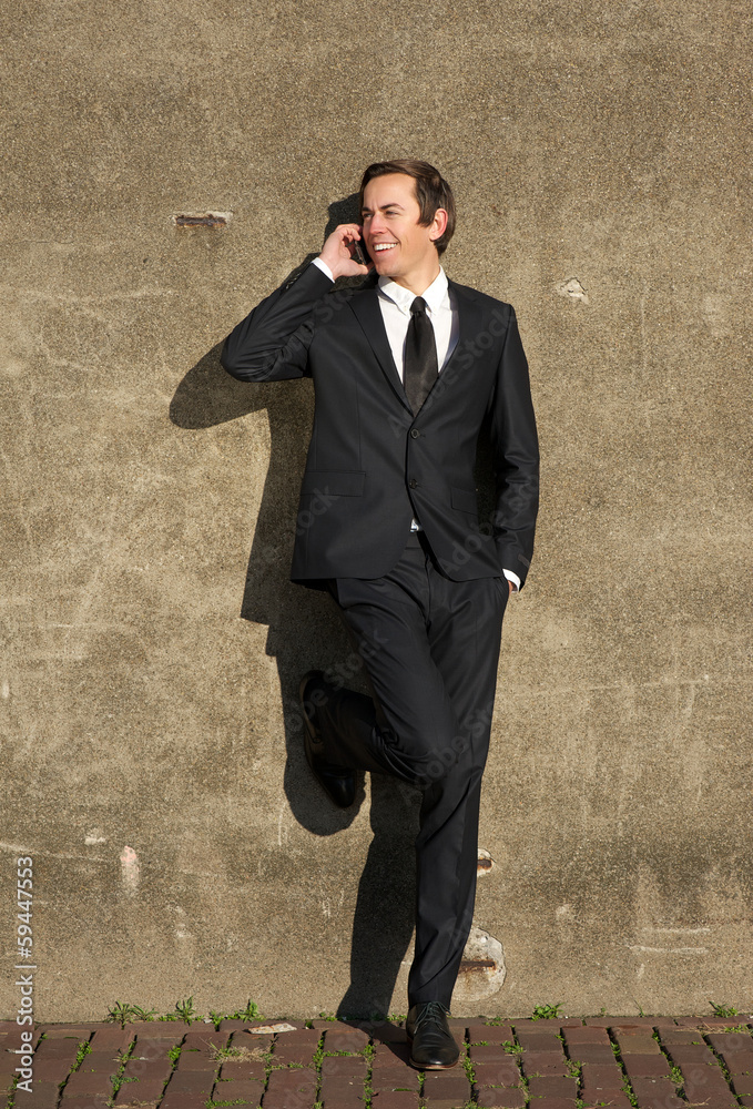 Businessman in black suit talking on mobile phone outdoors Businessman in black suit talking on mobile phone outdoors