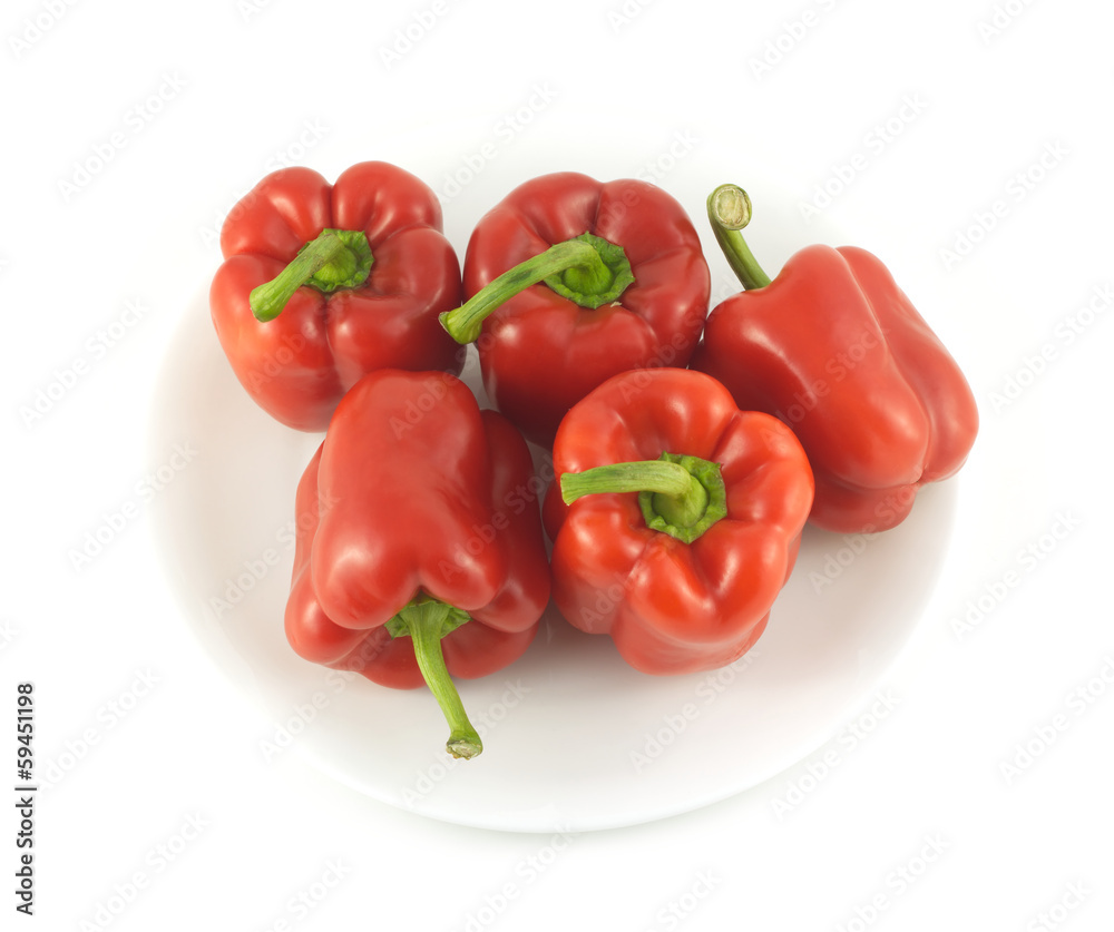 Five whole red ripe bell peppers isolated on white close up