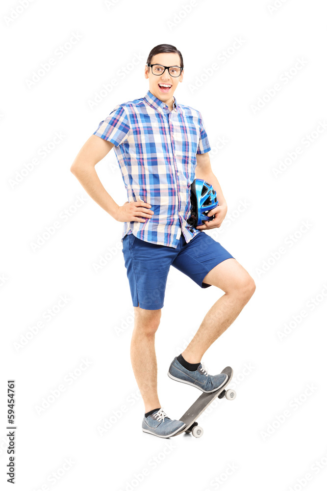 Smiling guy holding a helmet and standing on a skate board Smiling guy holding a helmet and standing on a skate board