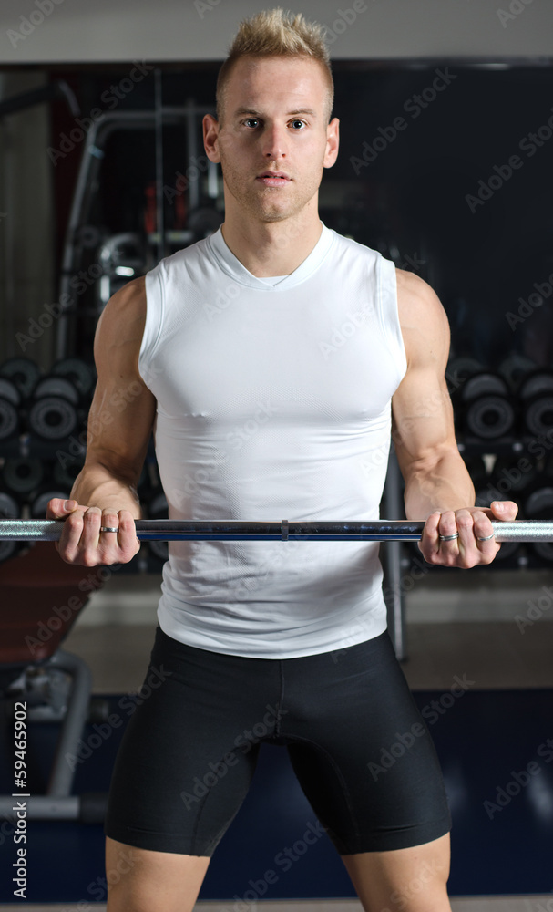 Handsome young man training biceps lifting barbell Handsome young man training biceps lifting barbell