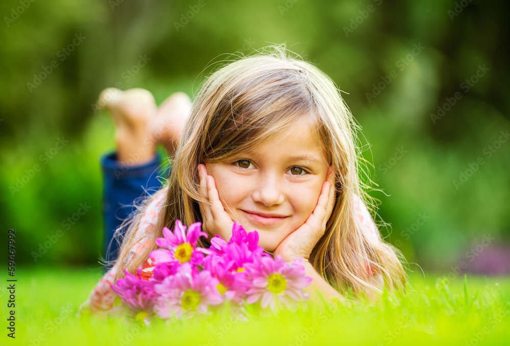 Portrait of a smiling little girl lying on green grass Portrait of a smiling little girl lying on green grass