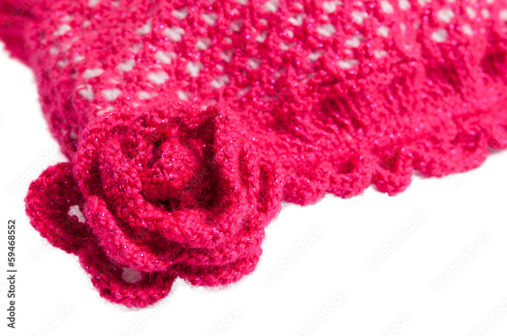Fototapeta premium Red-white knitted hat with flowers on a white background
