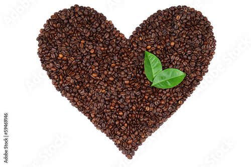 Heart made ​​from coffee beans and green leaves.