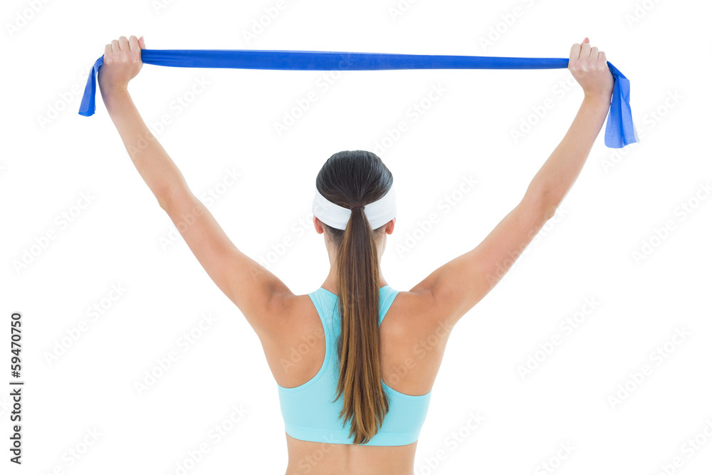 Rear view of a fit woman holding up a yoga belt Rear view of a fit woman holding up a yoga belt