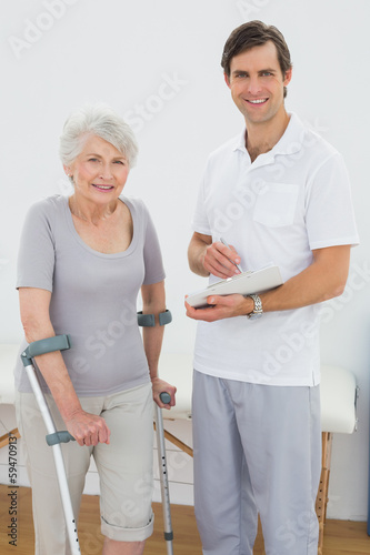 Therapist and disabled senior patient with reports