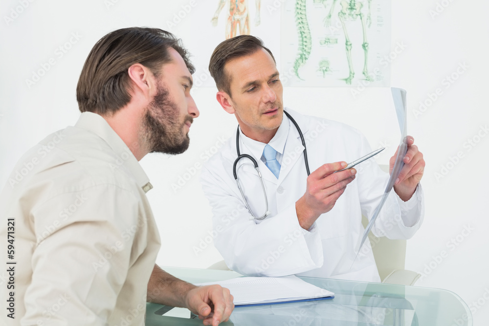 Male doctor explaining spine x-ray to patient Male doctor explaining spine x-ray to patient
