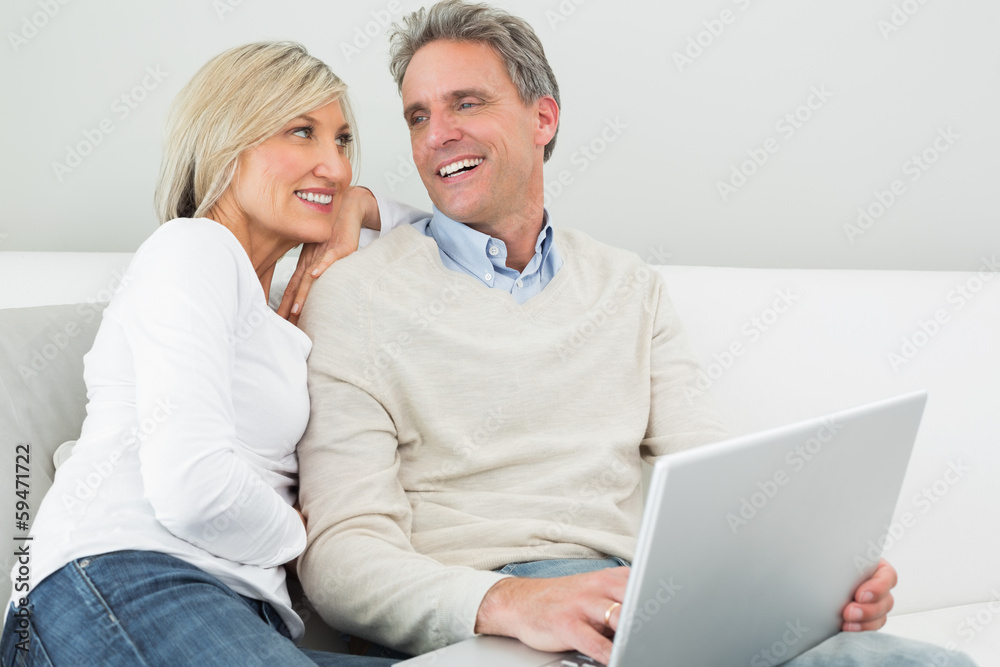 Happy casual couple using laptop in at home Happy casual couple using laptop in at home